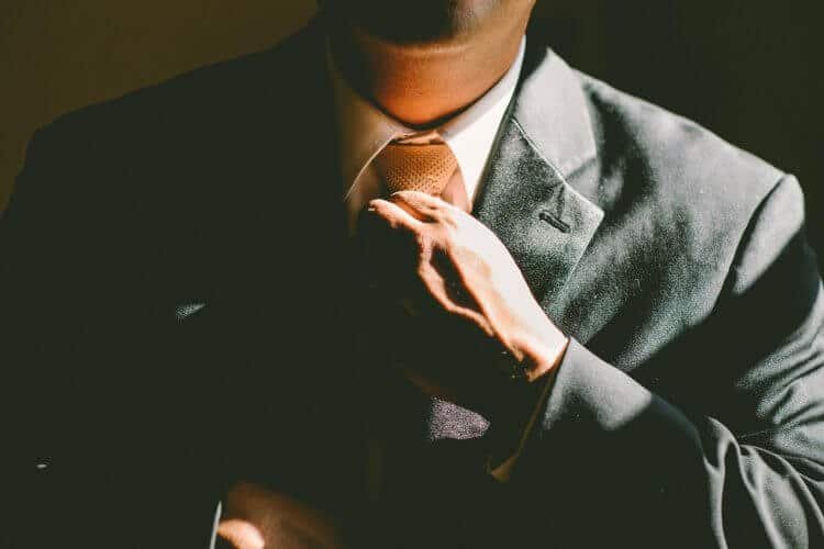 man adjusting a tie